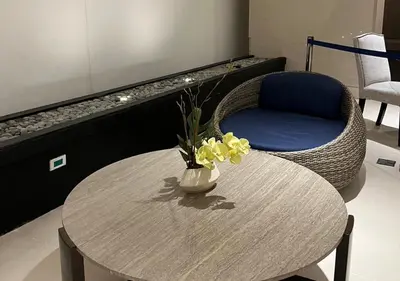 a table with a chair and a vase with flowers on it at Victoria Suite at Shore Residences in Manila