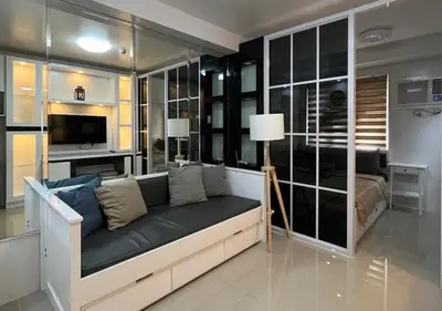 a living room with a couch and a television at Victoria Suite at Shore Residences in Manila