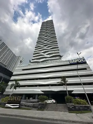 a tall building with a car parked in front of it at Chen's Cozy 2bedroom @ Coast Residences in Manila