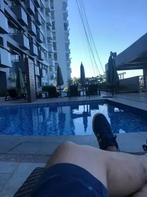 a person laying on the ground next to a swimming pool at Cubao Manhattanheights U31N TB, Studio Unit in Manila