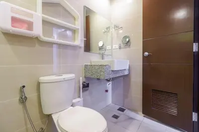 a bathroom with a white toilet and a sink at StayHere The Florence Luxe 1BR Near Venice Mall in Manila