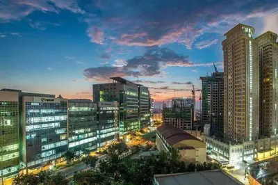 a city skyline with tall buildings at night at StayHere The Florence Luxe 1BR Near Venice Mall in Manila