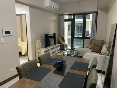 a living room with a table and a couch at StayHere The Florence Luxe 1BR Near Venice Mall in Manila