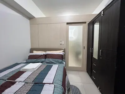 a small bedroom with a bed and a closet at Jazz Residences Makati in Manila