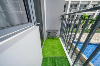 a balcony with grass next to a swimming pool at 2 Side-by-Side P00L Front Condos, 6 Beds, 2 CR, 2 Kitchen at MOA in Manila
