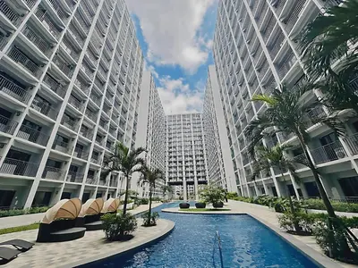 a swimming pool in front of two tall buildings at 2 Side-by-Side P00L Front Condos, 6 Beds, 2 CR, 2 Kitchen at MOA in Manila