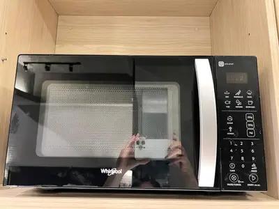 a person taking a picture of a microwave at Cozy Spacious Hotel Type Condo with PS5 Smart TV and WiFi in Manila