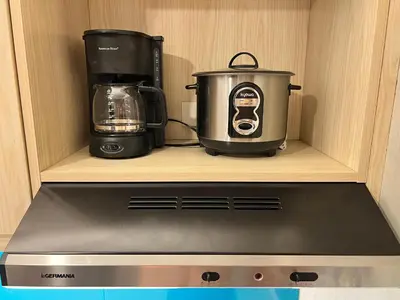 a coffeemaker and a toaster sitting on a shelf at Cozy Spacious Hotel Type Condo with PS5 Smart TV and WiFi in Manila