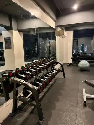 a gym with a row of exercise bikes in a room at Cozy Spacious Hotel Type Condo with PS5 Smart TV and WiFi in Manila