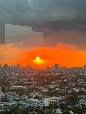 a city skyline with the sun setting in the sky at Cozy Spacious Hotel Type Condo with PS5 Smart TV and WiFi in Manila