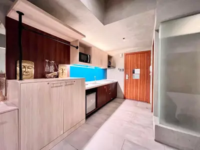 a kitchen with wooden cabinets and a blue at Cozy Spacious Hotel Type Condo with PS5 Smart TV and WiFi in Manila