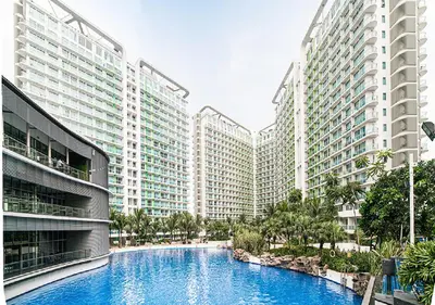 a swimming pool in the middle of two tall buildings at Azure Urban Resort Staycation by LV in Manila
