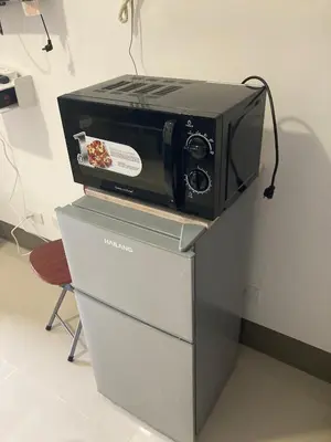 a toaster oven sitting on top of a refrigerator at Penthouse studio at Fame Residence 41st Floor, ShangriLa-Megamall in Manila