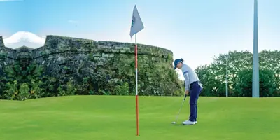 a man is playing golf on a golf course at Adria Residences - Emerald Garden - 2 Bedroom Unit for 4 person in Manila