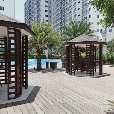 a wooden deck with a gazebo and a pool at Cozy 2BR corner unit in a prime location, your perfect city home in Manila