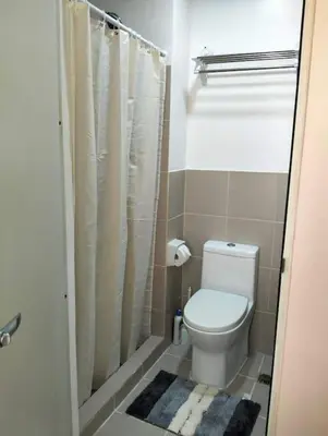 a small bathroom with a toilet and a shower at Cozy 2BR corner unit in a prime location, your perfect city home in Manila