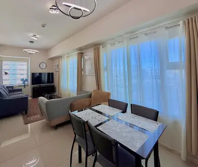 a living room with a dining table and a couch at 1 Bedroom Condo near US Embassy and St Lukes Medical Clinic in Manila