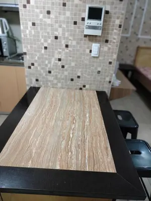 a wooden table in a room with a tiled wall at RQUI CONDOTEL in NAIA TERMINAL 3 at Two Palmtree Villas in Manila