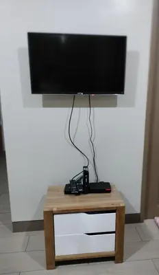 a flat screen tv sitting on top of a table at Room Across Naia Terminal 3 by Rqui in Manila