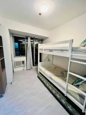 a room with two bunk beds and a window at Azure 2bedroom Condo With Balcony in Manila