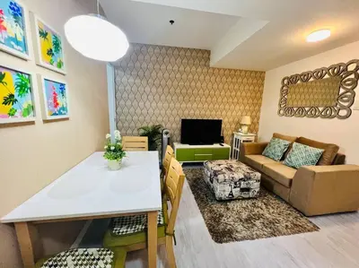 a living room with a table and a couch at Azure 2bedroom Condo With Balcony in Manila
