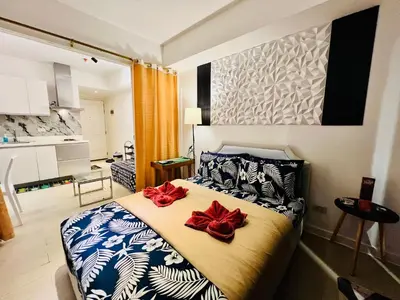 a bedroom with a bed with two red bows on it at Scr AzureINetflixIBalconyIGames in Manila