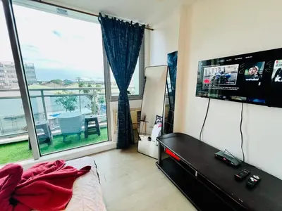 a living room with a tv and a large window at Scr AzureINetflixIBalconyIGames in Manila