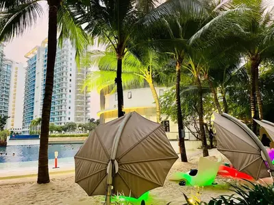 a beach with palm trees and umbrellas in the sand at Scr GlamourINetFlixIBalconyICozy in Manila