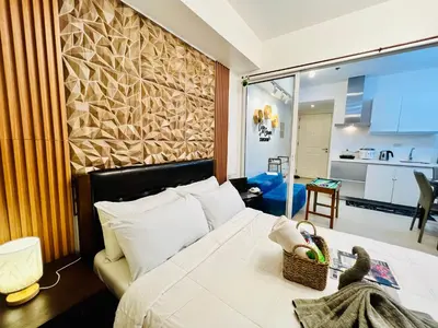a hotel room with a bed and a kitchen at Scr GlamourINetFlixIBalconyICozy in Manila