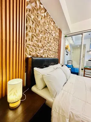 a bedroom with a bed and a wooden wall at Scr GlamourINetFlixIBalconyICozy in Manila