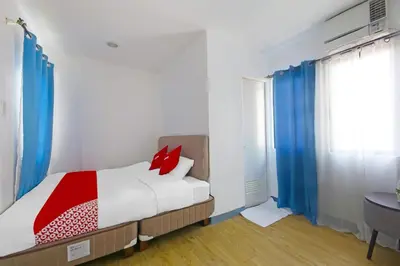 a bedroom with a bed and a bathroom with a sink at Loveness Apartelle in Manila