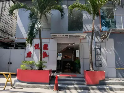 a building with two palm trees in front of it at Loveness Apartelle in Manila