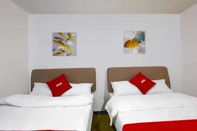two beds in a room with red and white pillows at Loveness Apartelle in Manila
