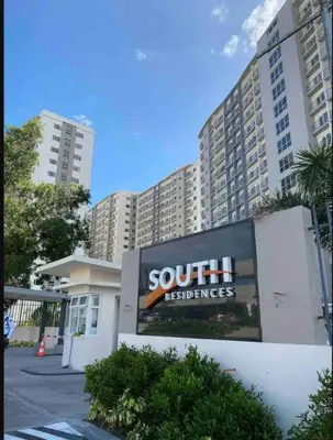 a large sign in front of a building with tall buildings at Chic 2BR Condo Unit at South Residences in Manila