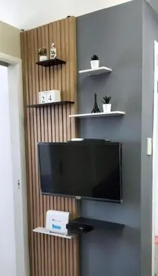 a flat screen tv on a wall with shelves at Chic 2BR Condo Unit at South Residences in Manila