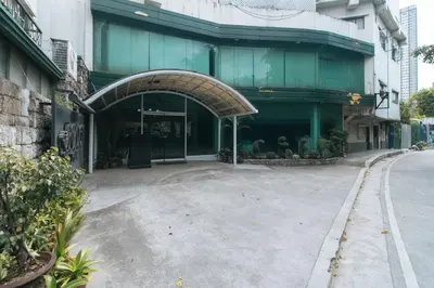 a building with an archway in the middle of a street at Garden Plaza Hotel Manila in Manila