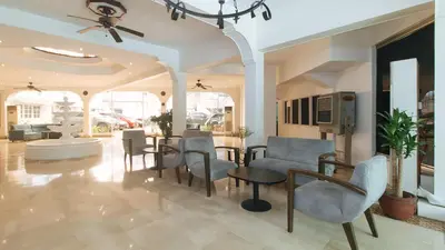 a living room with a table and chairs at Garden Plaza Hotel Manila in Manila