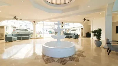 a large lobby with a fountain in the middle of a room at Garden Plaza Hotel Manila in Manila