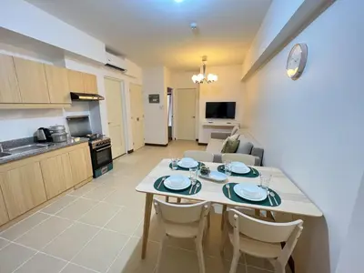 a kitchen and living room with a table and chairs at Infina Towers Affordable staycation in Manila