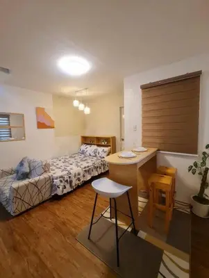 a bedroom with a bed and a desk and a table at Muji-Inspired, Studio-Type Home at Phirst Park Homes Tanza in Tanza