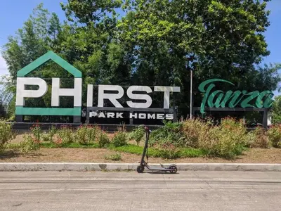 a scooter parked on the street in front of a sign at Muji-Inspired, Studio-Type Home at Phirst Park Homes Tanza in Tanza