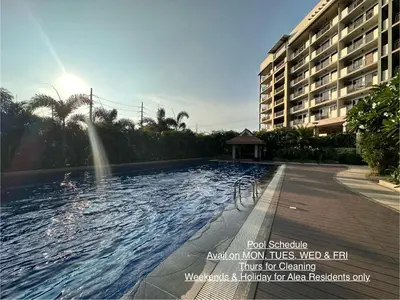 a swimming pool in front of a large building at Alea Residences in Manila