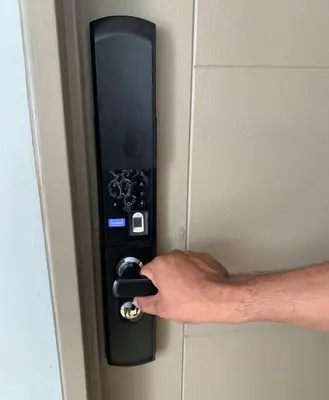 a hand is unlocking a door with a key at Alea Residences in Manila