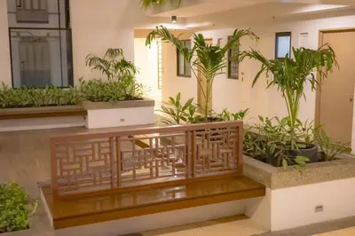 a room with potted plants and a wooden bench at Alea Residences in Manila