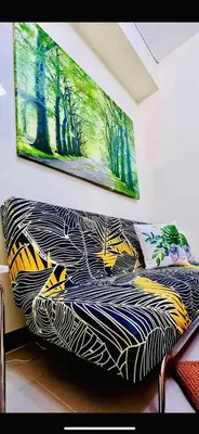 a couch in a room with a painting on the wall at Field Residence SMDC 1BR w/ Netflix in Manila