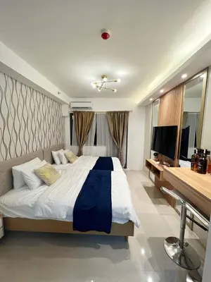 a bedroom with a large bed and a television at M&M Condostay at Shore 2 Residences Tower 2 Pasay City in Manila