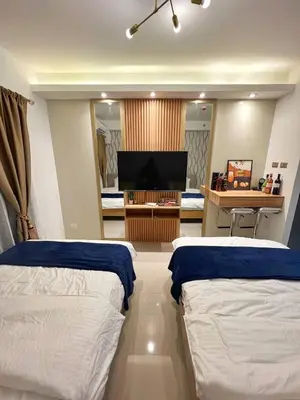 a room with two beds and a television in it at M&M Condostay at Shore 2 Residences Tower 2 Pasay City in Manila