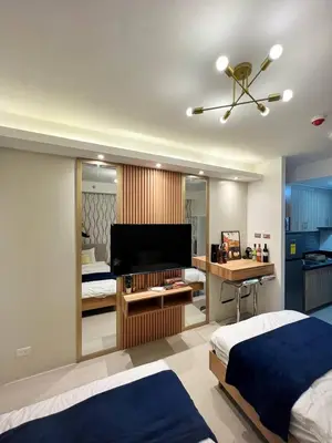 a bedroom with a bed and a desk with a piano at M&M Condostay at Shore 2 Residences Tower 2 Pasay City in Manila