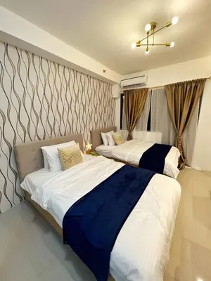 two beds in a hotel room at M&M Condostay at Shore 2 Residences Tower 2 Pasay City in Manila