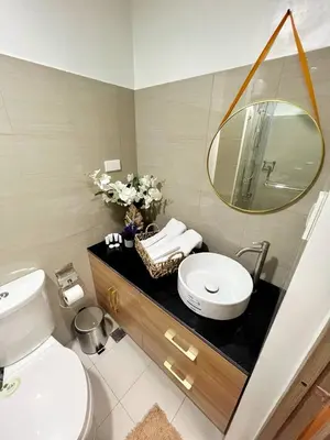 a bathroom with a toilet and a sink and a mirror at M&M Condostay at Shore 2 Residences Tower 2 Pasay City in Manila